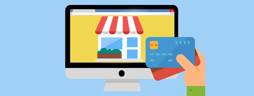 Online shopping with a storefront on a computer screen and a hand holding a credit card.